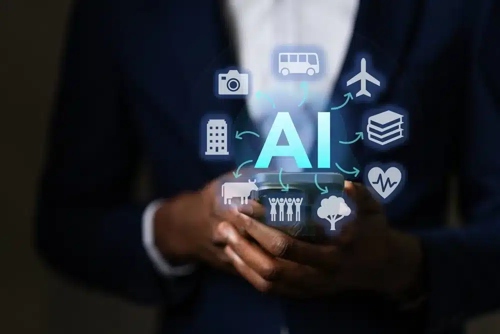 A person holding a phone with the word "AI" floating on top of it and digital travel-related icons floating around it.