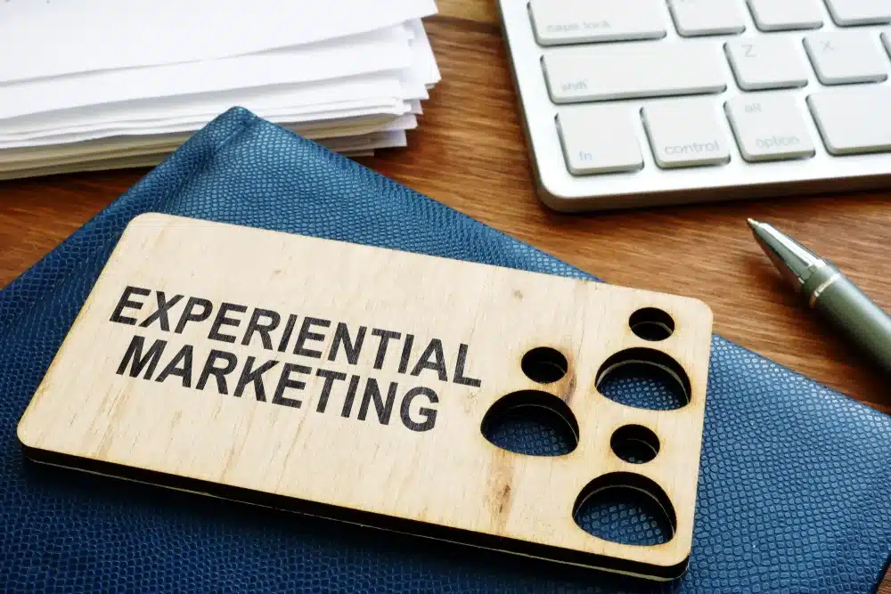 woodcut token that reads "Experiential Marketing" on a desk.