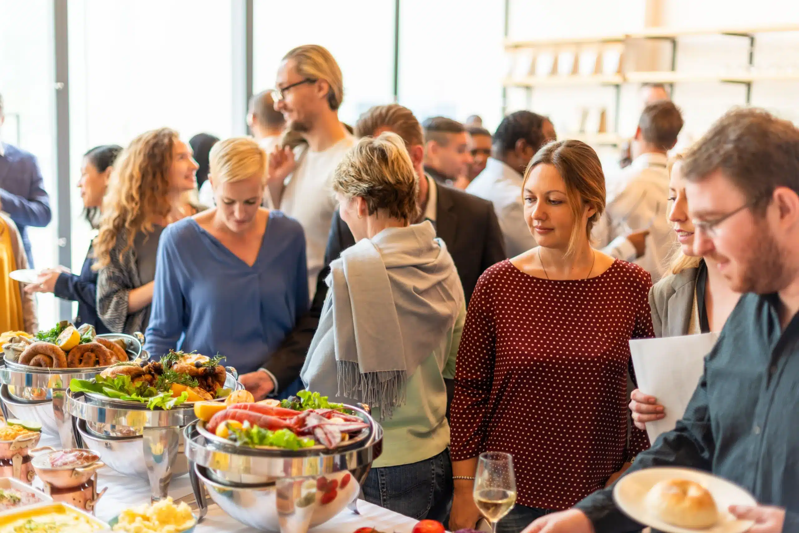 Diverse group of people enjoying food and socializing at a catered event